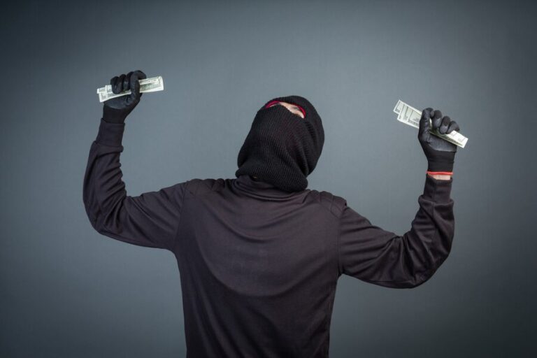 criminals-wear-black-masks-hold-dollar-cards-gray_1150-15142