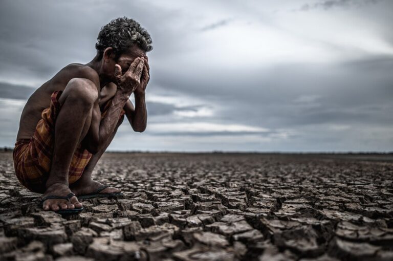 elderly-man-sat-bent-his-knees-dry-ground-hands-closed-his-face-global-warming_1150-16280