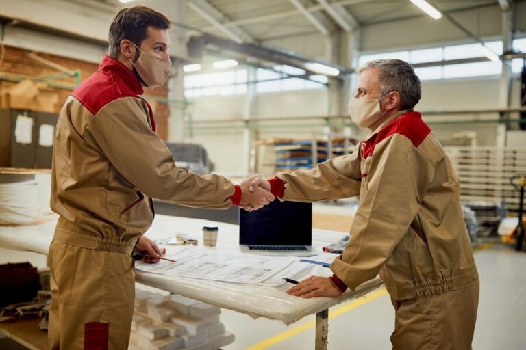 two-carpenters-with-face-masks-congratulating-each-other-successful-project-workshop_637285-11797