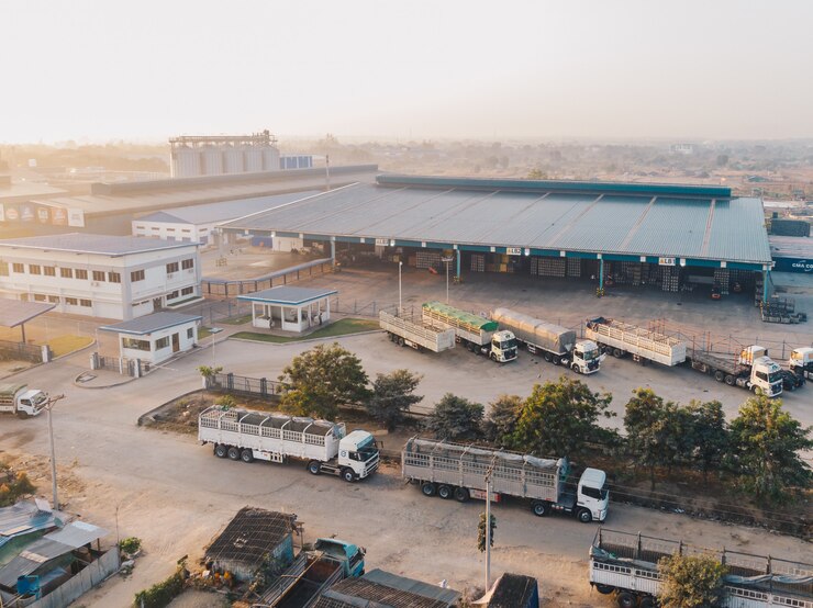 aerial-view-factory-trucks-parked-near-warehouse-daytime_181624-4593