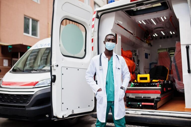 african-male-paramedic-face-protective-medical-mask-standing-front-ambulance-car_627829-4934